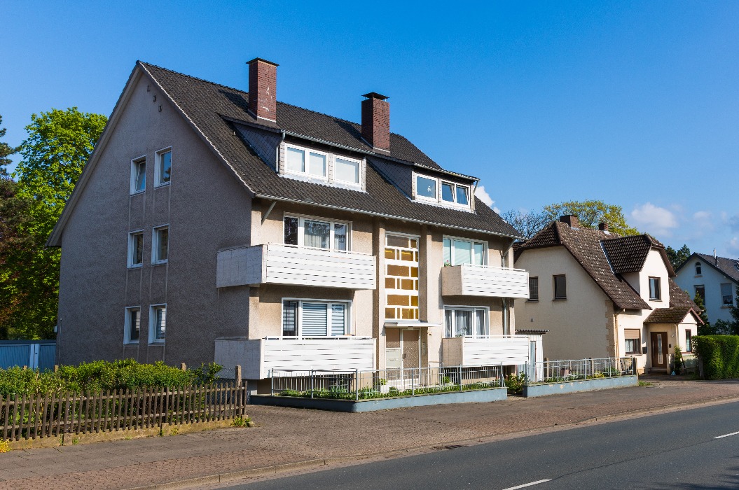 Älteres Mehrfamilienhaus an einer Hauptstraße